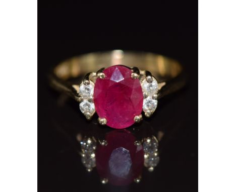 A 14k gold ring set with an oval cut ruby of approximately 1.5ct and four diamonds, 3.4g, size O
