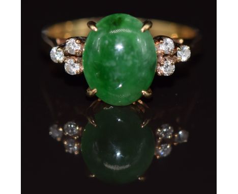 A yellow metal ring set with a jadeite cabochon and diamonds, 3g, size K