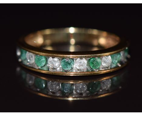 A 10k gold half eternity ring set with alternating emeralds and diamonds, 2.5g, size L