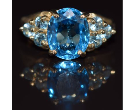 A 9ct gold ring set with oval and round cut blue topaz, 4.8g, size N