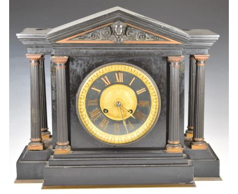 Black slate or marble cased French mantel clock with part gilt dial with pediment above and flanked by columns, striking on a