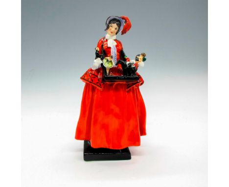Dressed in red with black bonnet, carrying tray of small figurines around her neck. Made for The Sketch magazine in the 1920'