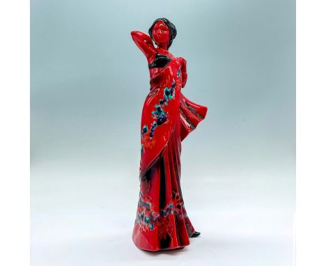 Glazed figure of a lady in a long dress with sash over her left shoulder. Red with accents of cobalt blue, orange, turquoise 