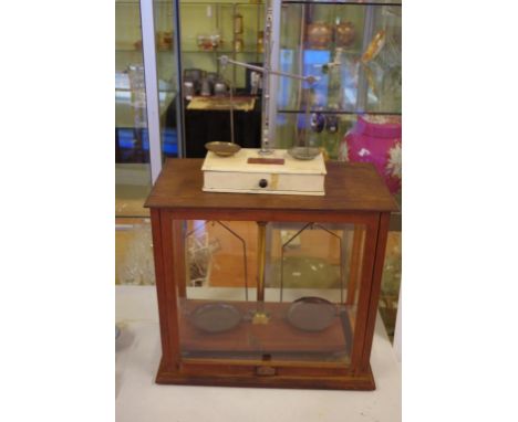 Two sets of vintage balance scales comprising of a cased set 52cm wide, 47.5cm high and  a smaller Wedderburn set
