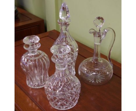 Three good cut crystal decanters together with a Victorian Greek key etched decanter
