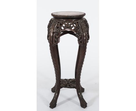 A Chinese carved hardwood circular jardiniere stand: the top inset with a panel of rouge variegated marble with a gadrooned e