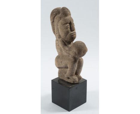 A Pre-Columbian/Mayan carved volcanic rock figure of a ball game player: seated and holding a ball between both hands, 45 cm 