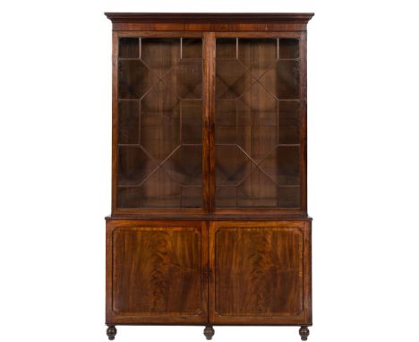 An early 19th Century mahogany library bookcase:, the upper part with a moulded cornice, fitted with adjustable shelves enclo