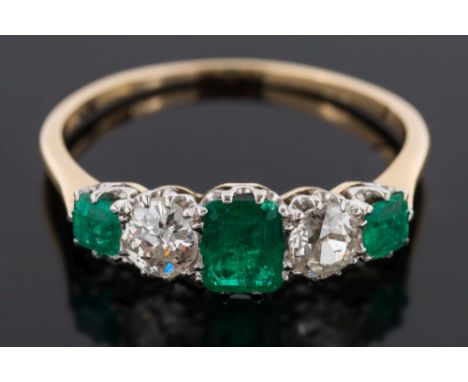 A gold, emerald and diamond five-stone ring: with three graduated rectangular emeralds separated by round old brilliant-cut d