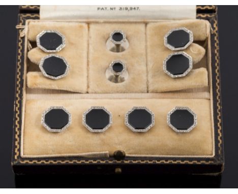 A suite of early 20th century 18ct white gold, black onyx and diamond cuff-links, buttons and studs: each with an octagonal b