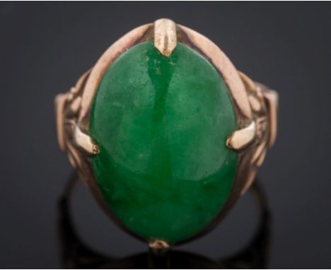 An oval jade single-stone ring: with foliate design shoulders the shank stamped '14K', ring size K 1/2. 