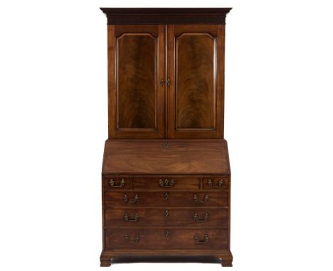 A George III mahogany bureau cabinet:, the upper part with a moulded dentil cornice and blind fret carved frieze, having a fi