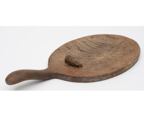 By Robert Thompson of Kilburn 'The Mouseman' an oak cheese platter: of oval outline with swept handle, 37.5cm. long.