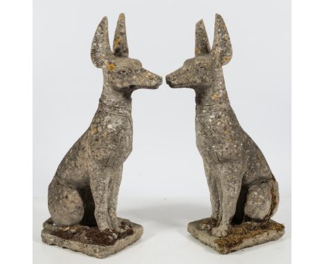 A pair of reconstituted stone figures of Egyptian hunting dogs:, seated on their haunches on a naturalistic base 88cm  high.