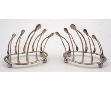 A pair of Edward VII silver four-division wishbone toast racks, maker William Hutton & Sons, Birmingham, 1905: on oval bases 