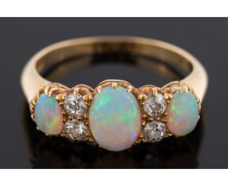 A gold, opal and diamond seven-stone ring: claw-set with graduated, oval opals between circular old-cut diamonds, ring size L