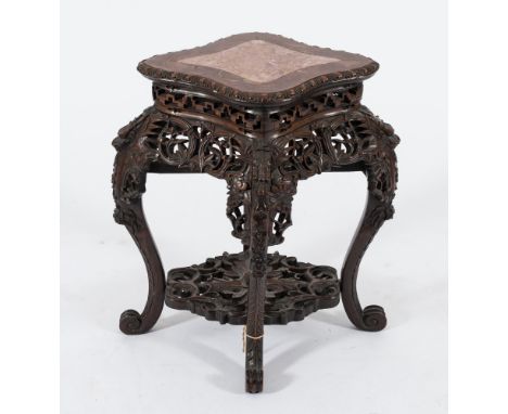 A Chinese carved hardwood jardiniere stand:, of navette shaped outline, the top inset with a panel of rouge variegated marble