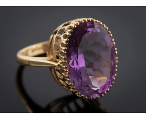 An 18ct gold and oval amethyst single-stone dress ring: the oval amethyst approximately 19.5mm long x 15mm wide within deep p