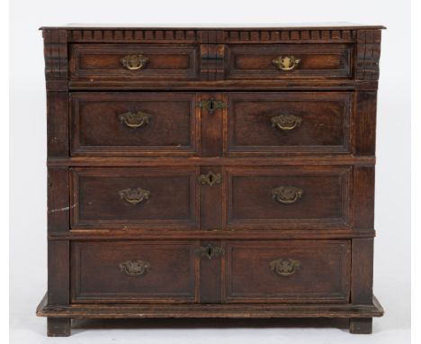 A 17th Century oak rectangular chest:, the top with a dentil edge, containing four long moulded panel drawers, on block feet,