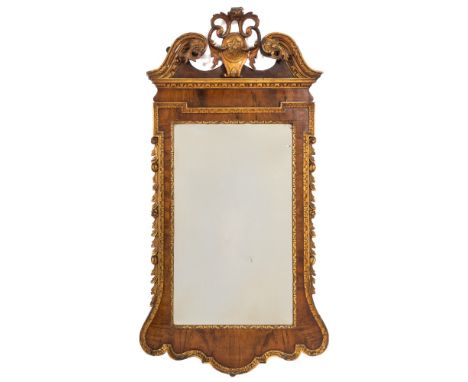 A late 19th Century walnut and carved giltwood mirror:, in the early 18th Century taste, the moulded and incised swan neck br