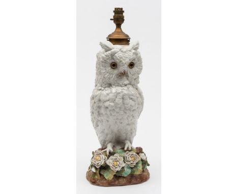 An English porcelain paraffin lamp in the form of a Long Eared Owl: modelled perched on a rustic base applied with flowers an