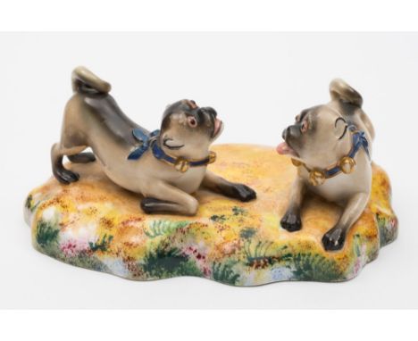 A Worcester porcelain pug group: after a Meissen original, depicting two crouching pugs at play each wearing blue ribbons and