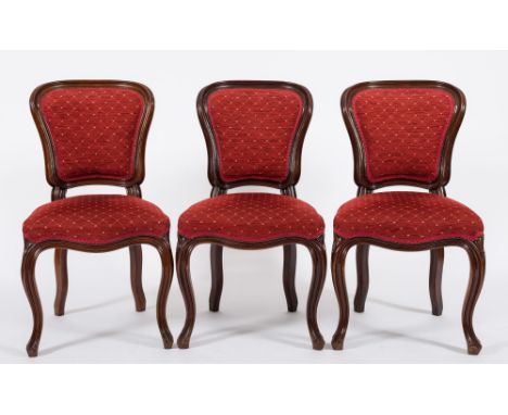 A set of six Victorian mahogany dining chairs:, in the French taste with upholstered cartouche, shaped panel backs in moulded