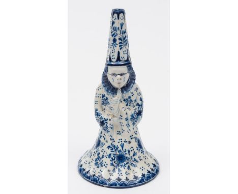 A Dutch delft figural table bell: in the form of a standing wizard-like figure with tall hat, spectacles, ruff collar and bro