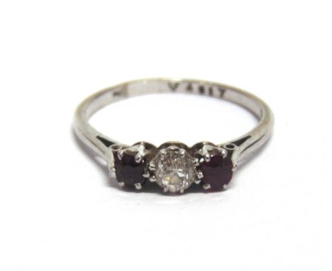 A DIAMOND AND RUBY THREE STONE RING  the white mount unmarked, the old cut diamond of approximately 0.25 carats, finger size 