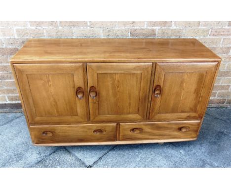 AN ERCOL LIGHT ELM SIDEBOARD  fitted with three doors above pair of drawers, 130cm wide 44cm deep 76cm high