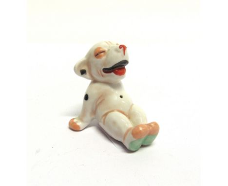 A CERAMIC MODEL OF BONZO THE DOG  in smiling, seated pose, after the character by G.E. Studdy, 6cm long. 