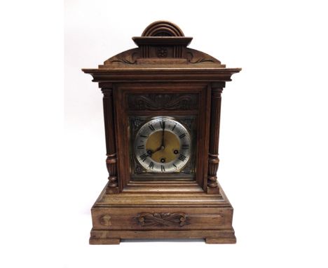 A CONTINENTAL WALNUT MANTLE CLOCK  with 8-day Jungans movement, the silvered chapter ring with Roman numerals, 32cm wide 22cm