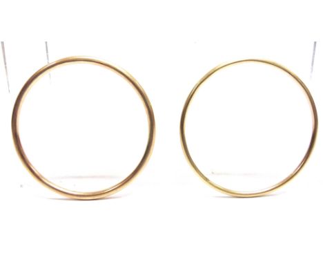 A BANGLE  stamped '585', of plain round section; and another similar; both internal diameters 6.6cm, 19.8g gross.