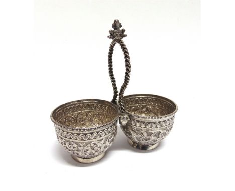 A GOOD INDIAN SILVER DOUBLE BOWL  unmarked, the embossed and chased bowls united by a cord loop handle with Vishnu finial, an
