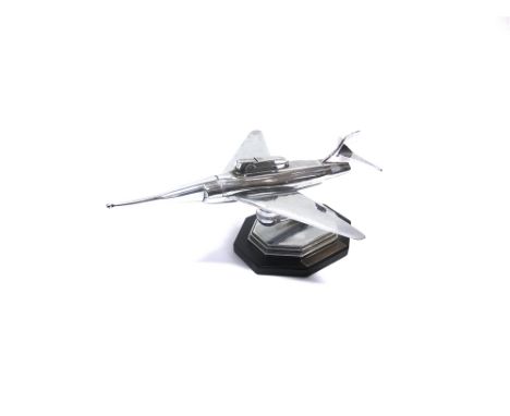 A NOVELTY CHROMED TABLE LIGHTER, IN THE FORM OF A JET AIRCRAFT  on a bakelite type base, with applied retirement presentation