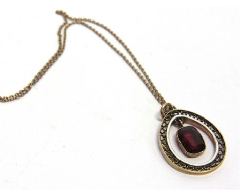 A SYNTHETIC RUBY PENDANT  circa 1920, the rounded rectangular cut stone within a tear shape frame with white enamel trim, unm