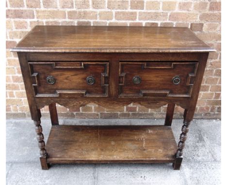 AN OAK SIDE TABLE  the two frieze drawers with moulded decoration, on turned supports with pot shelf base, 106cm wide 45cm de