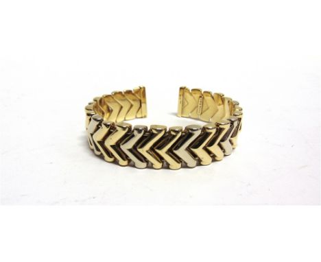 A SPRUNG TORQUE STYLE BANGLE  stamped '750', with chevron links, internal diameter 6.2cm, 40g gross.