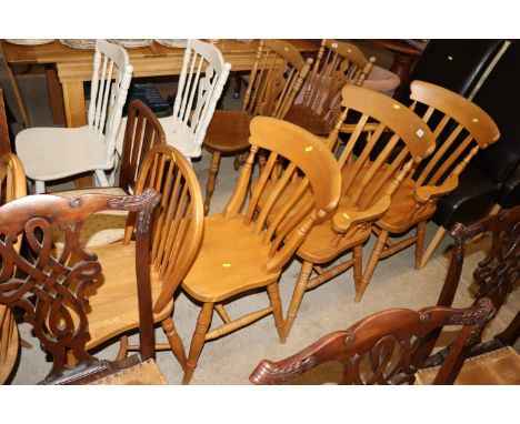 A pair of pine and elm seated kitchen elbow chairs; a matching single chair; and a similar stick back chair 