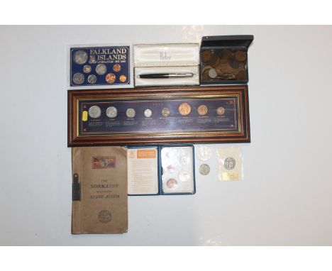 A framed and glazed display of coins; a 1982 Falkland Island coin set; Britain's First Decimal coin set and various other coi