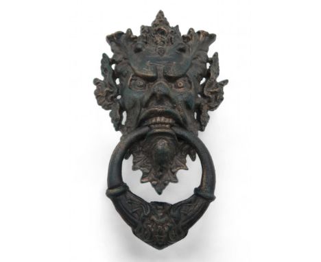 A large cast iron door knocker modelled as a grotesque mask, 33cm high Condition Report:Available upon request