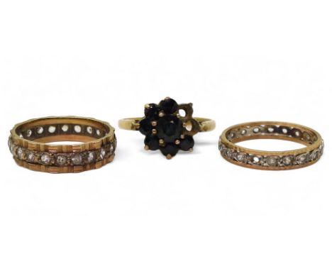 A 9ct gold clear gem set eternity ring, size Q1/2, an (af) sapphire flower ring, size R1/2, and a further yellow and white me