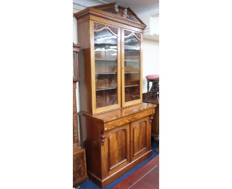 A 19th century mahogany glazed library bookcase with carved architectural style cornice over pair of glazed doors on married 