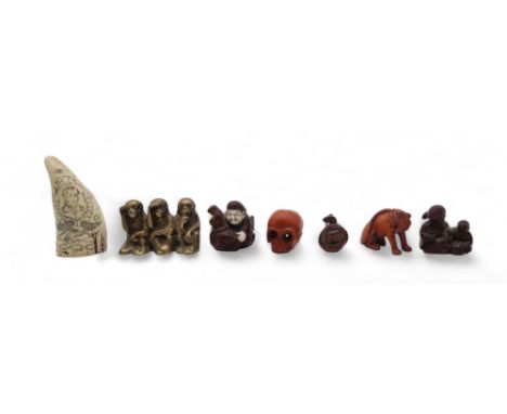 A collection of carved mahogany and fruitwood netsuke, including a skull, lion, snake, a man and a mouse, a mother and child,