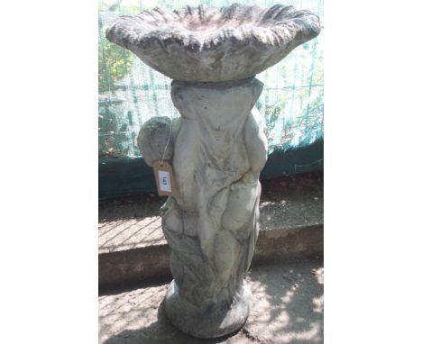 A 20th century reconstituted stone garden birdbath modelled as a pair of cherubim figures supporting scalloped basin, 66cm hi