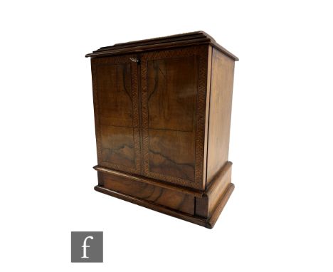 A Victorian figured walnut table cabinet fitted with three drawers, recessed brass handles, enclosed by a Tunbridgeware bande