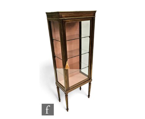 A late 19th Century French Empire style brass mounted floor standing display cabinet, adjustable glass shelf interior on turn