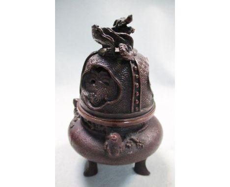 A copper patinated bronze censer and cover, the latter surmounted by a dragon and pierced with three quatrefoils containing m