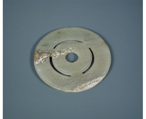 A jade bi disc, possibly Han dynasty, pierced with three arcs to create two circular bands of raised bosses, the stone a pale