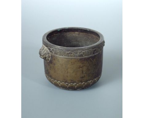 An 18th century bronze censor, the rim of the cylindrical sides cast with lotus band above horned lion mask handles, the roun